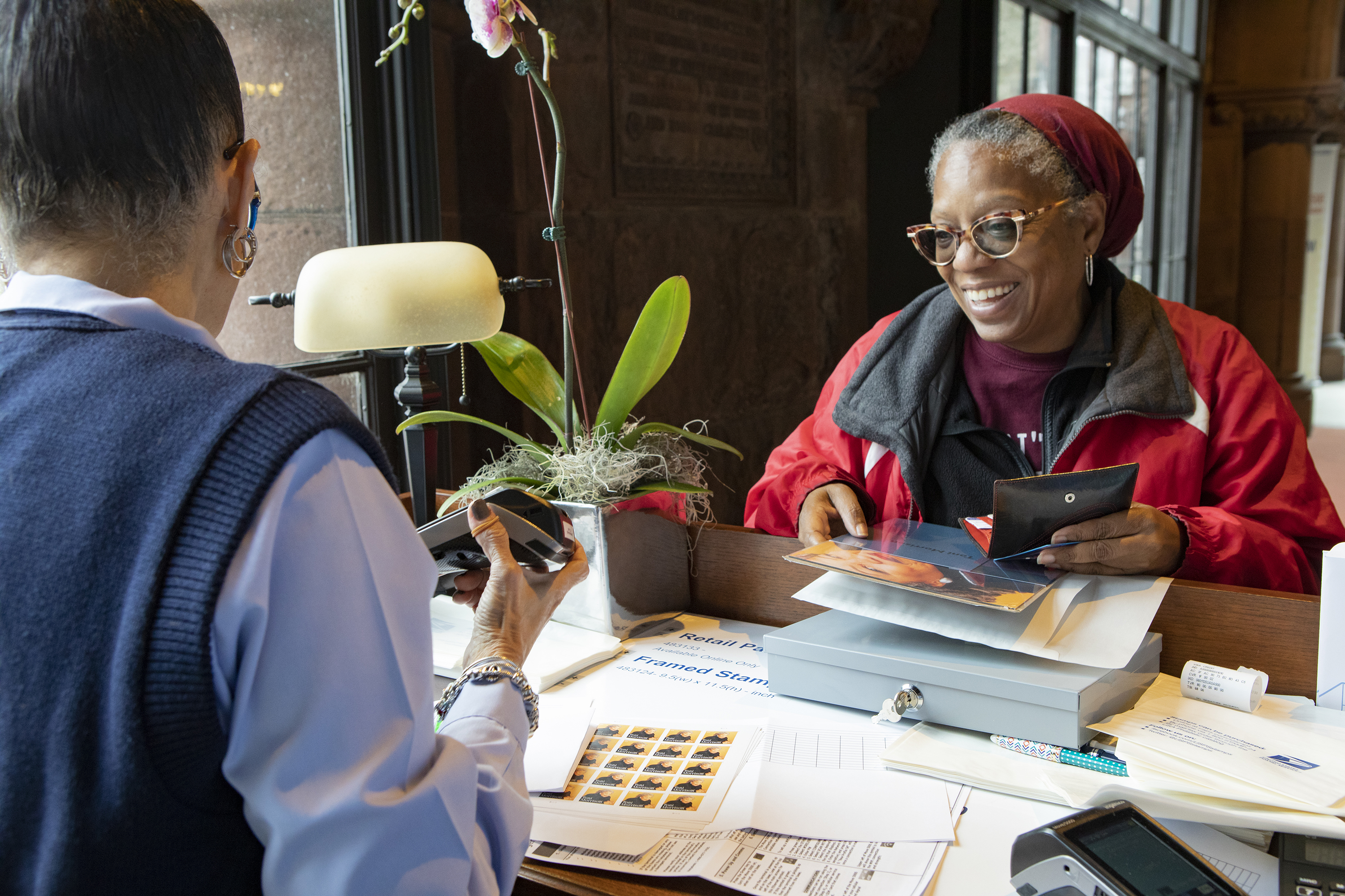 Lady smiling purchasing Toni Morrison stamp