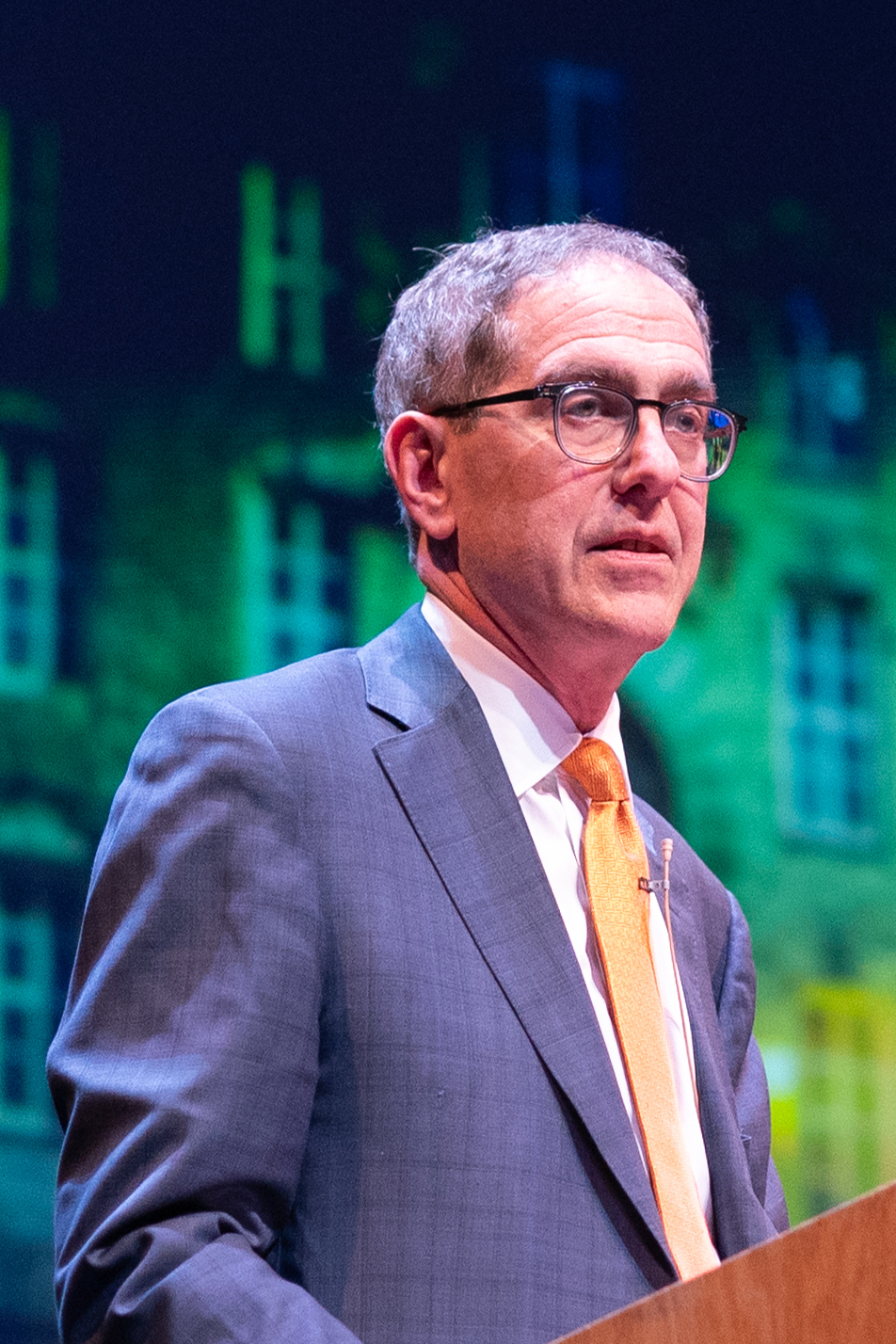 President Eisgruber speaking at the podium on the Matthews Stage of McCarter Theatre