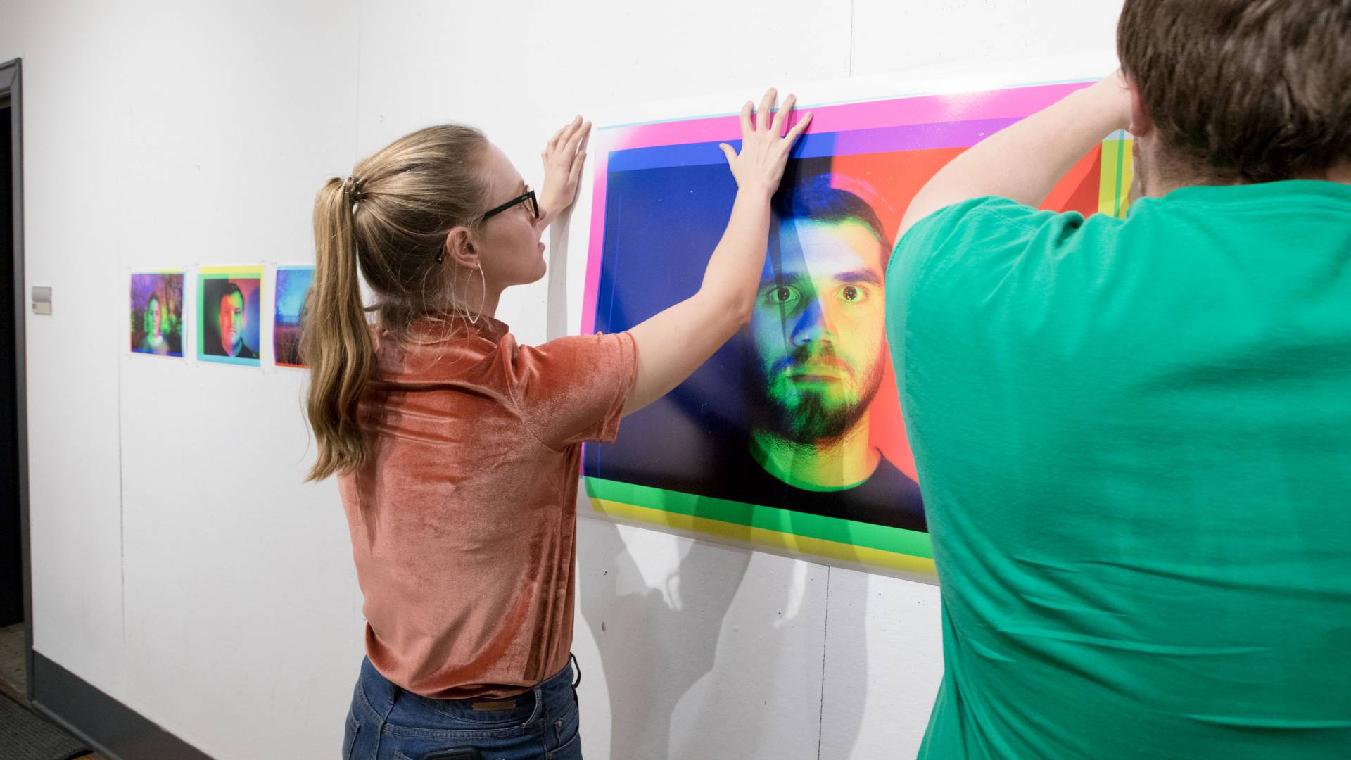 Students hang their project up on wall for class critique
