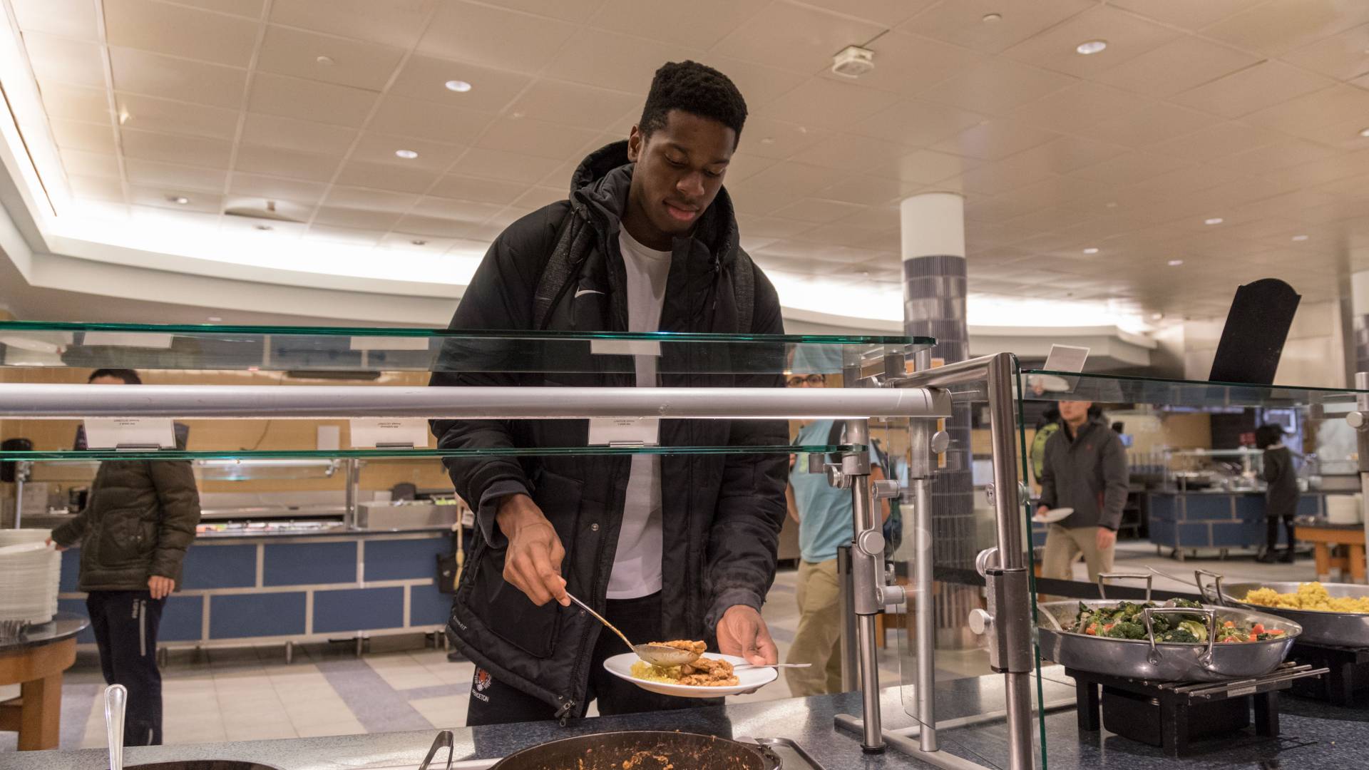 Student putting food on plate 