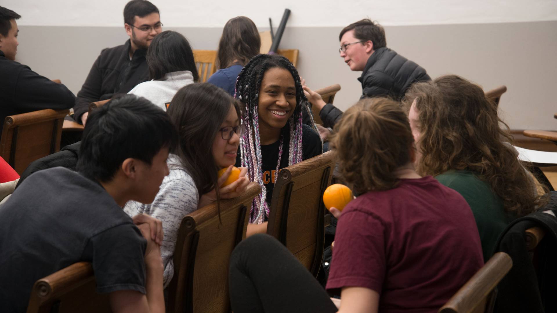 Students talking in class on how to peel an orange