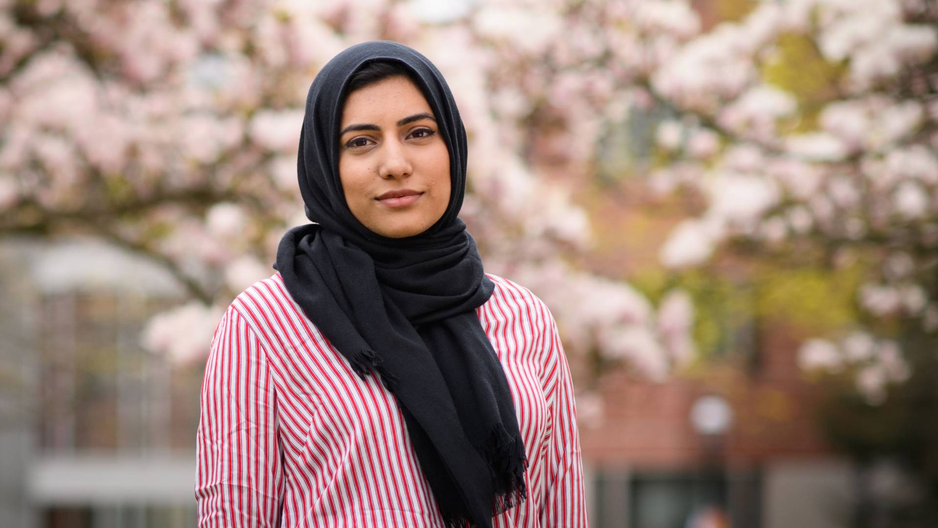 Rabia Khan standing in front of blossoming trees