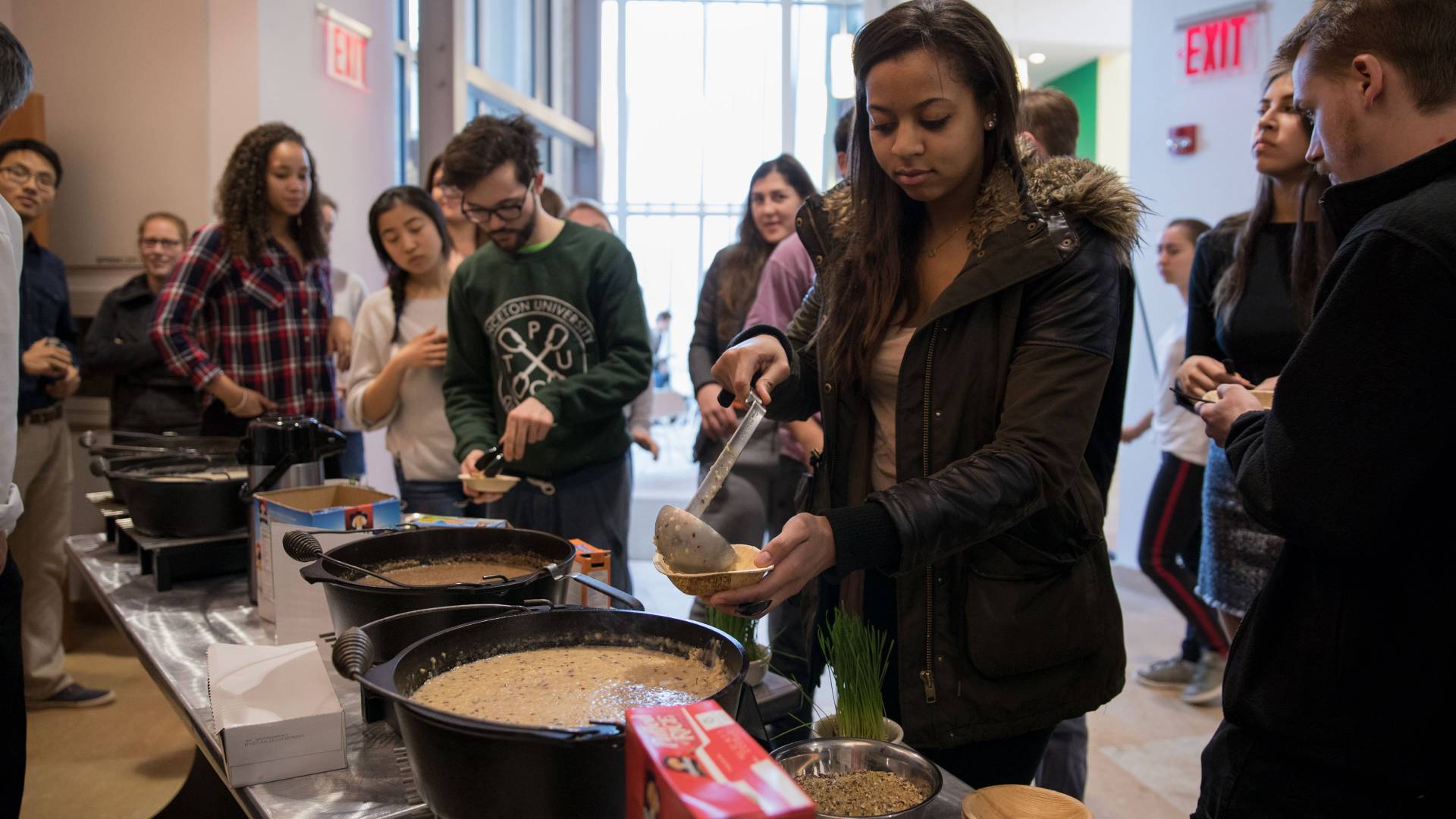 Student ladling cooked oats into bowls