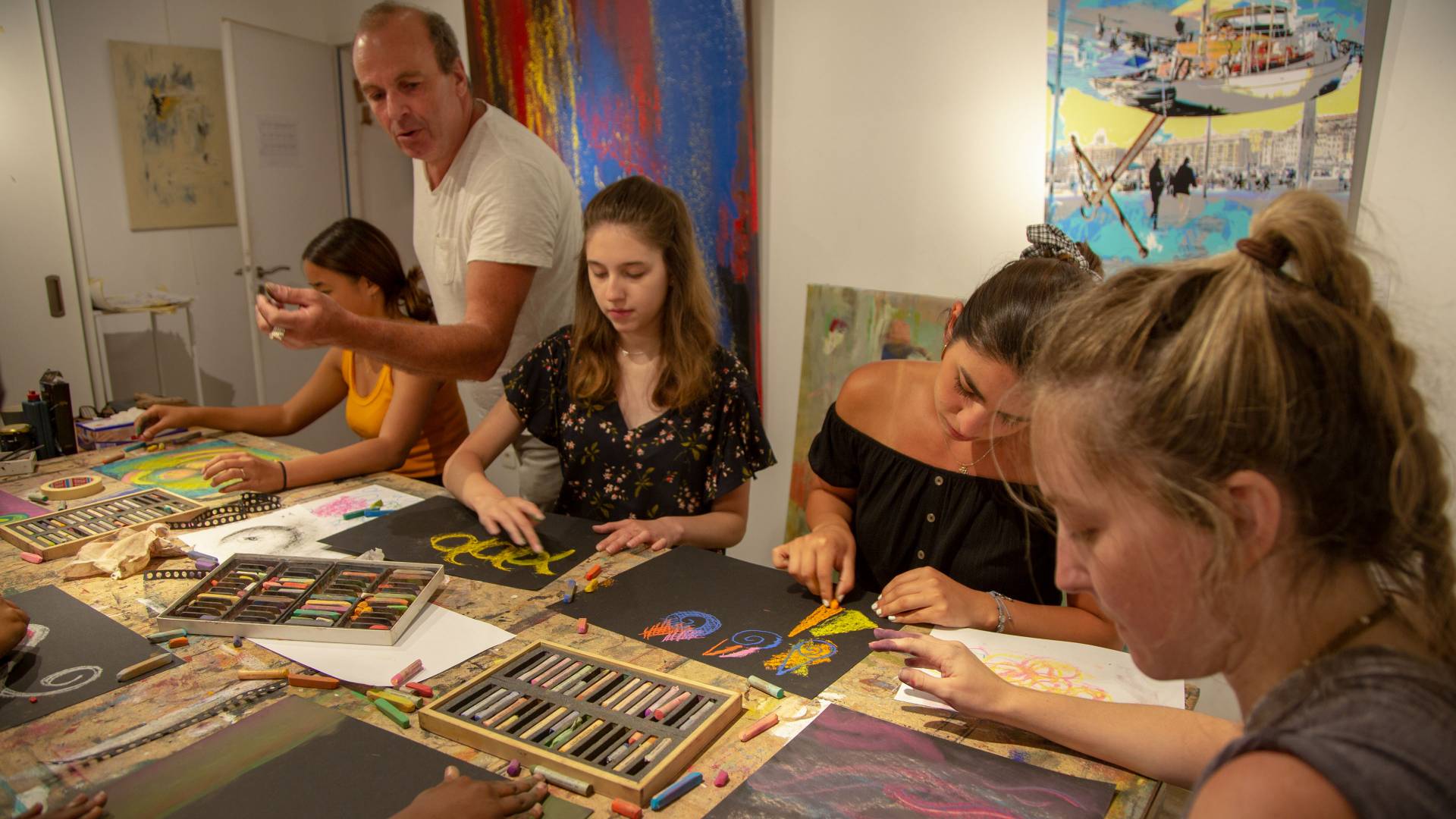 Students working on art projects with instructor in France