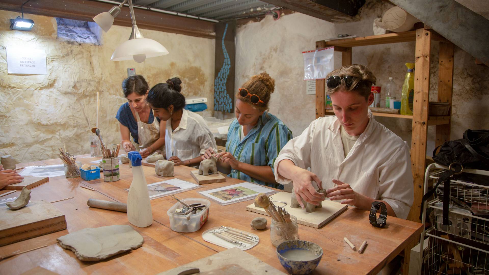 Students working on art projects with instructor in France