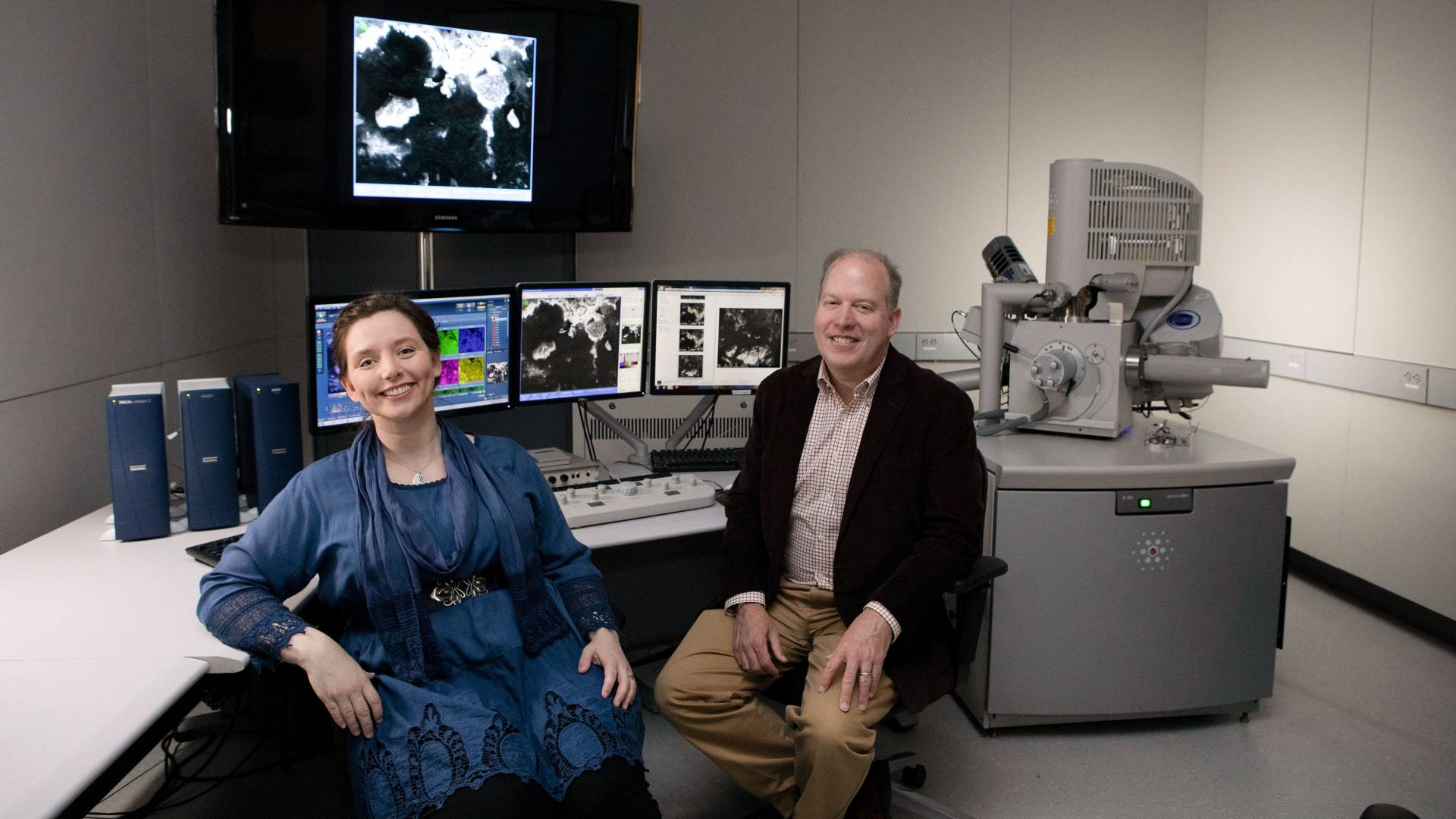 Rachel Selinsky and Thomas Conlan sitting in front of high-tech equipment