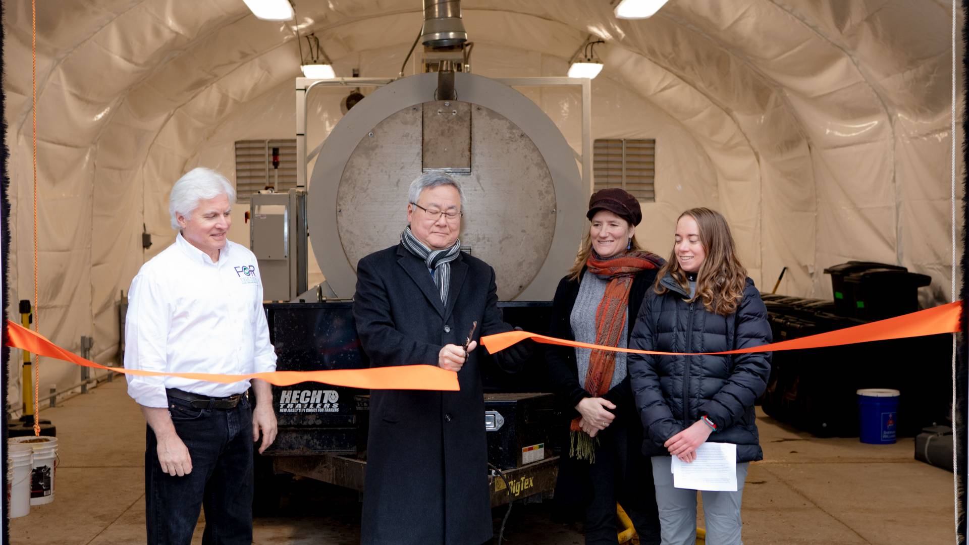 KyuJung Whang cutting ribbon in front of biodigester