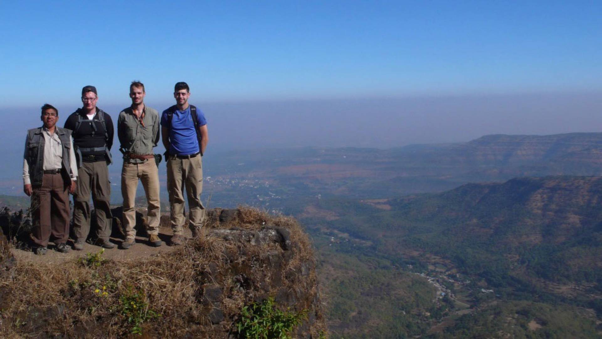 Researches standing on ridge with view of landscape behind them