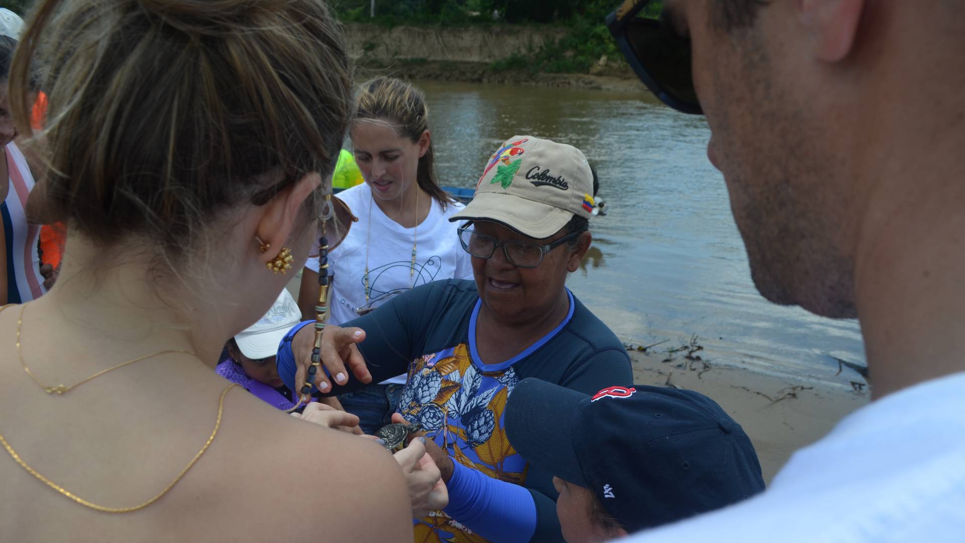 Women showing small turtle to onlookers