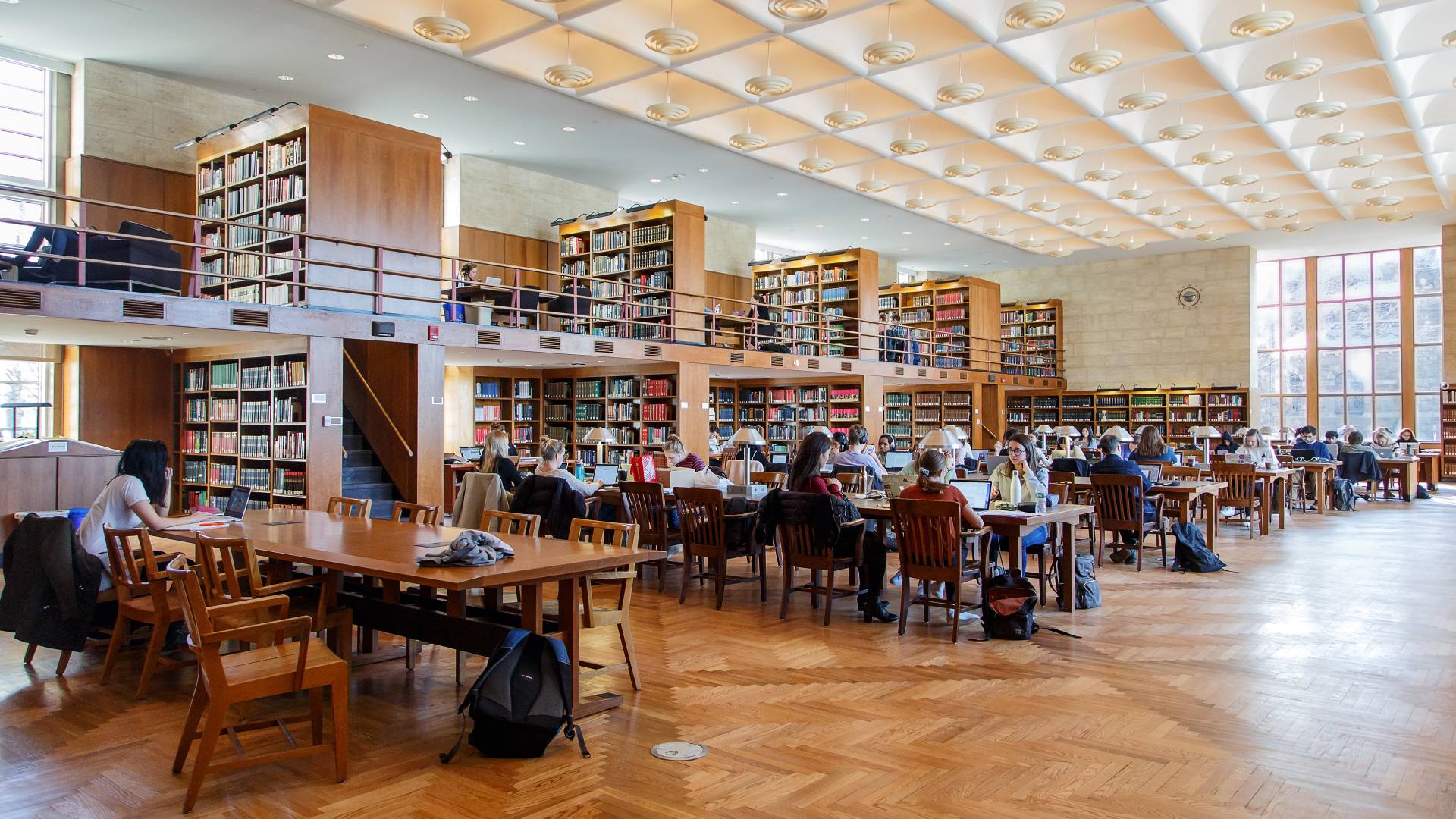 Students studying at tables in library room