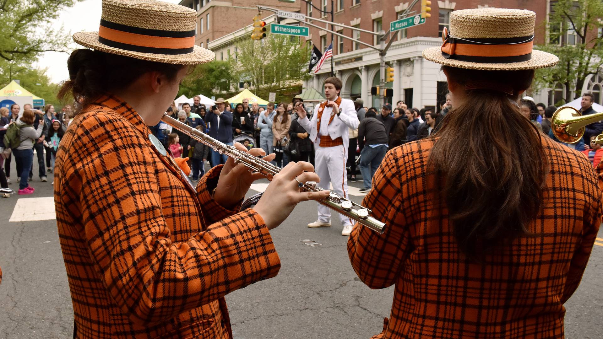 The Princeton Band conductor is seen through 2 memers of the band, one of whom is playing the flute