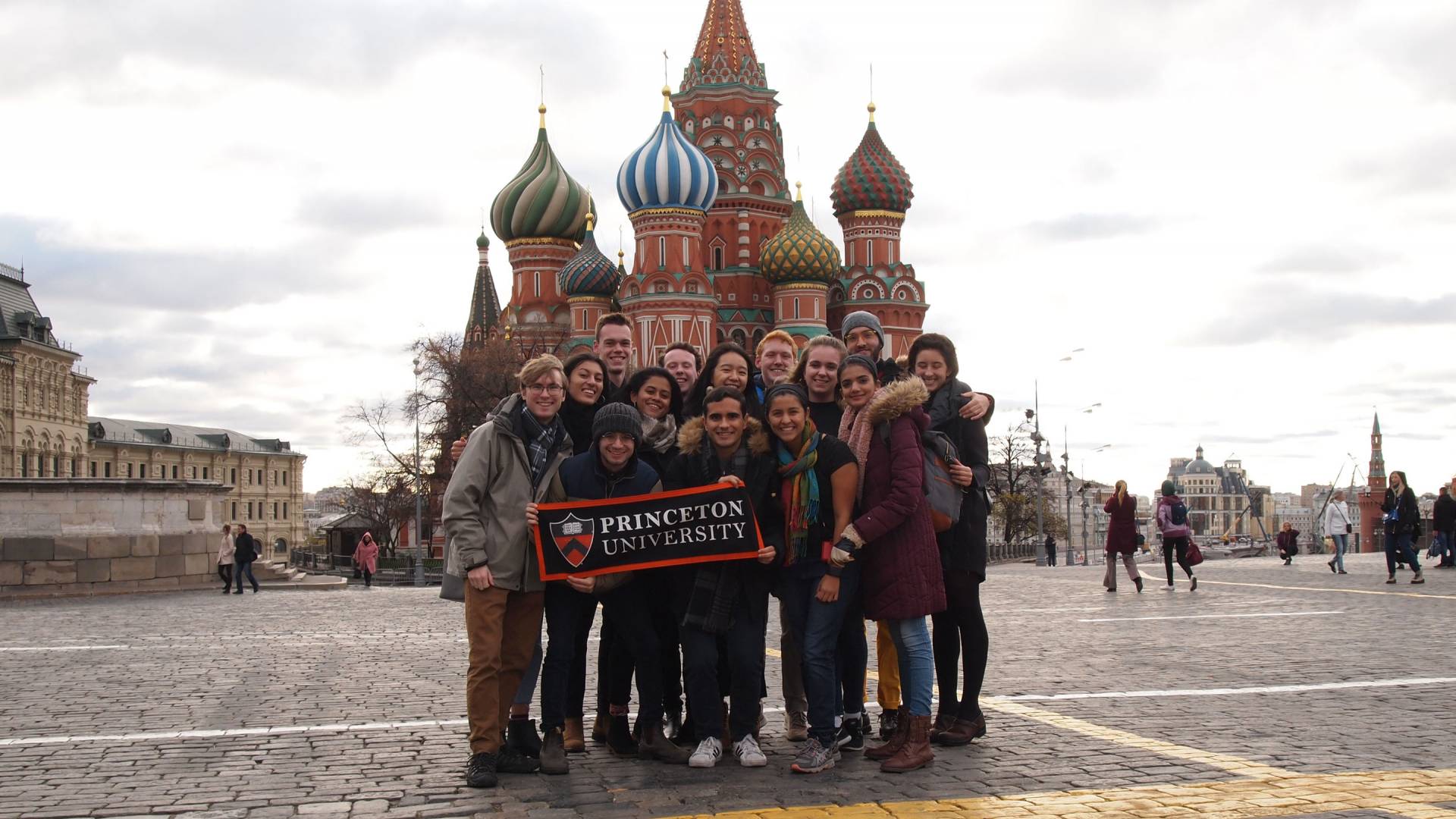 Students holding Princeton banner in front of buildings