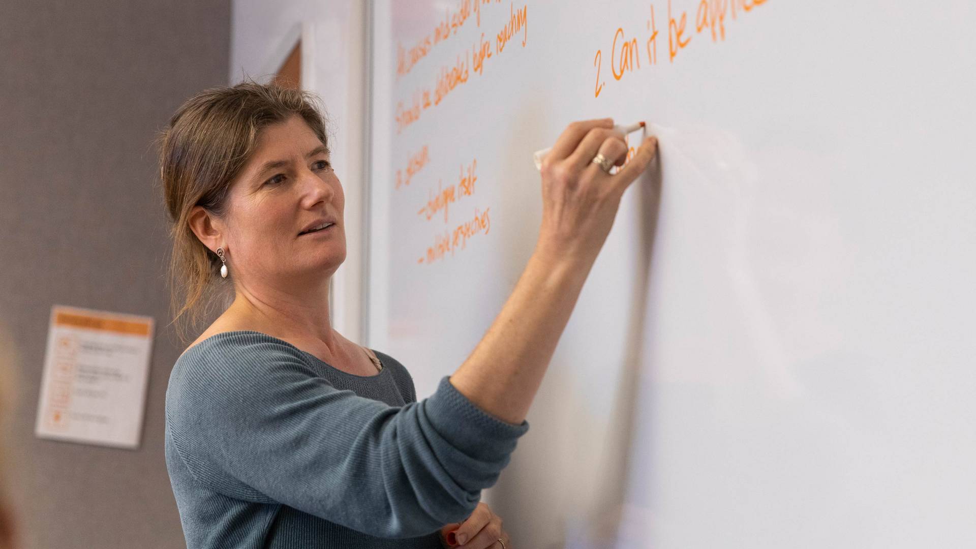 Shana Weber writes on a whiteboard