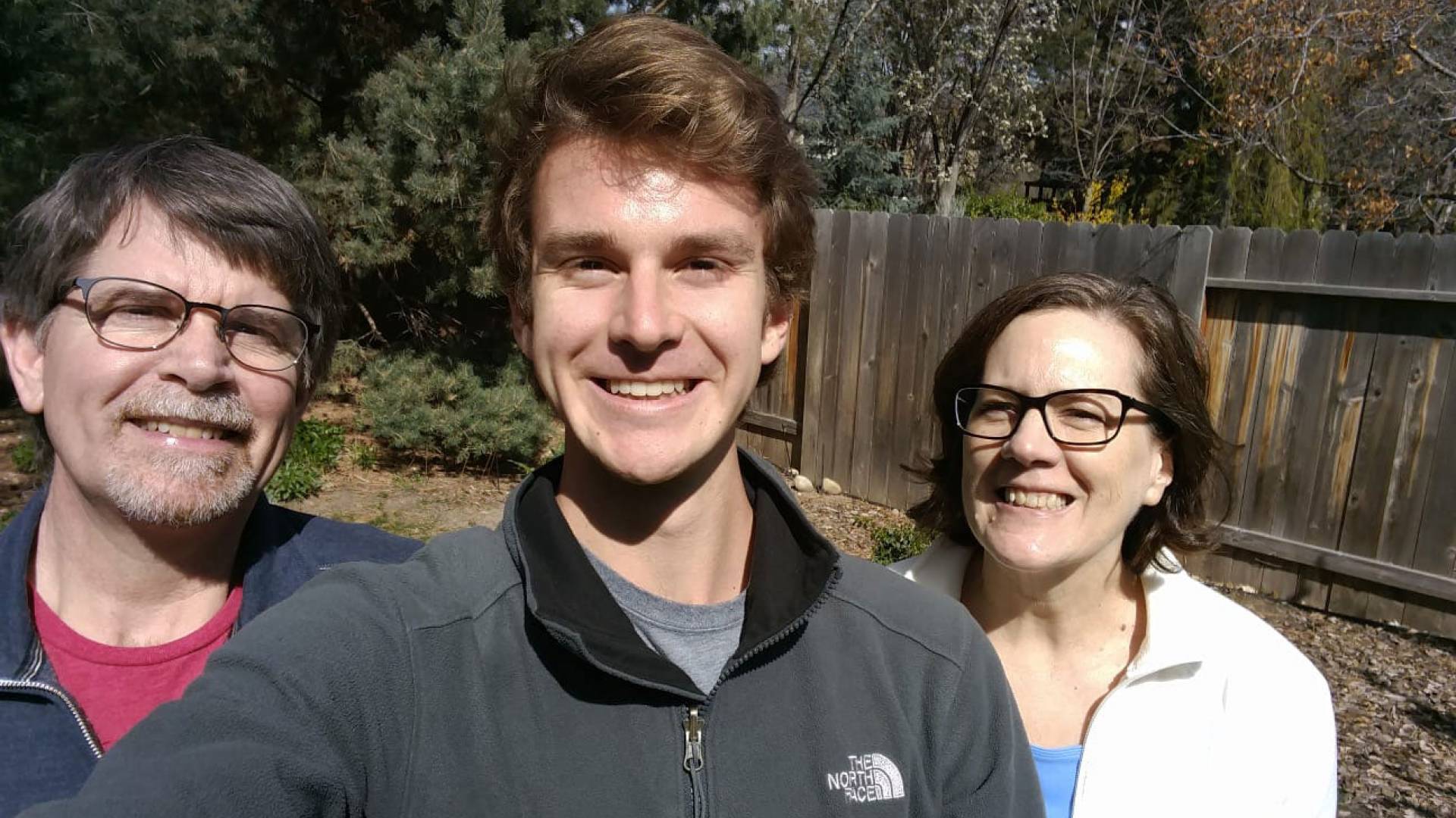 A student takes a selfie with his parents