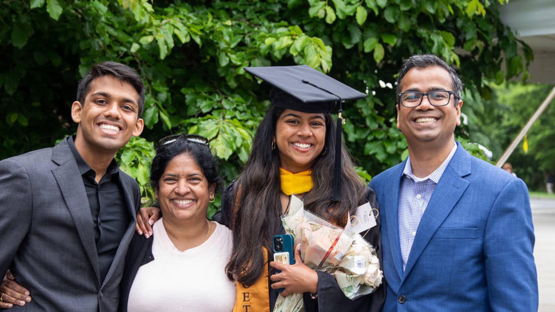 Smiling family members with graduate at Commencement.