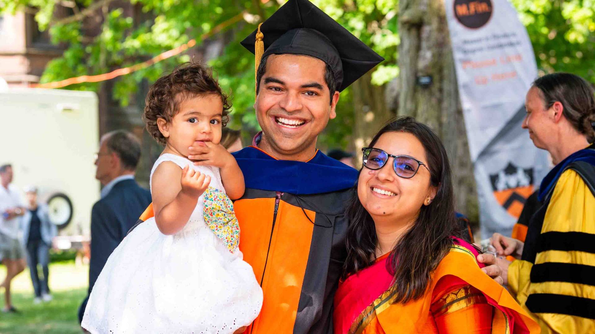 Graduating student smiling with his family.