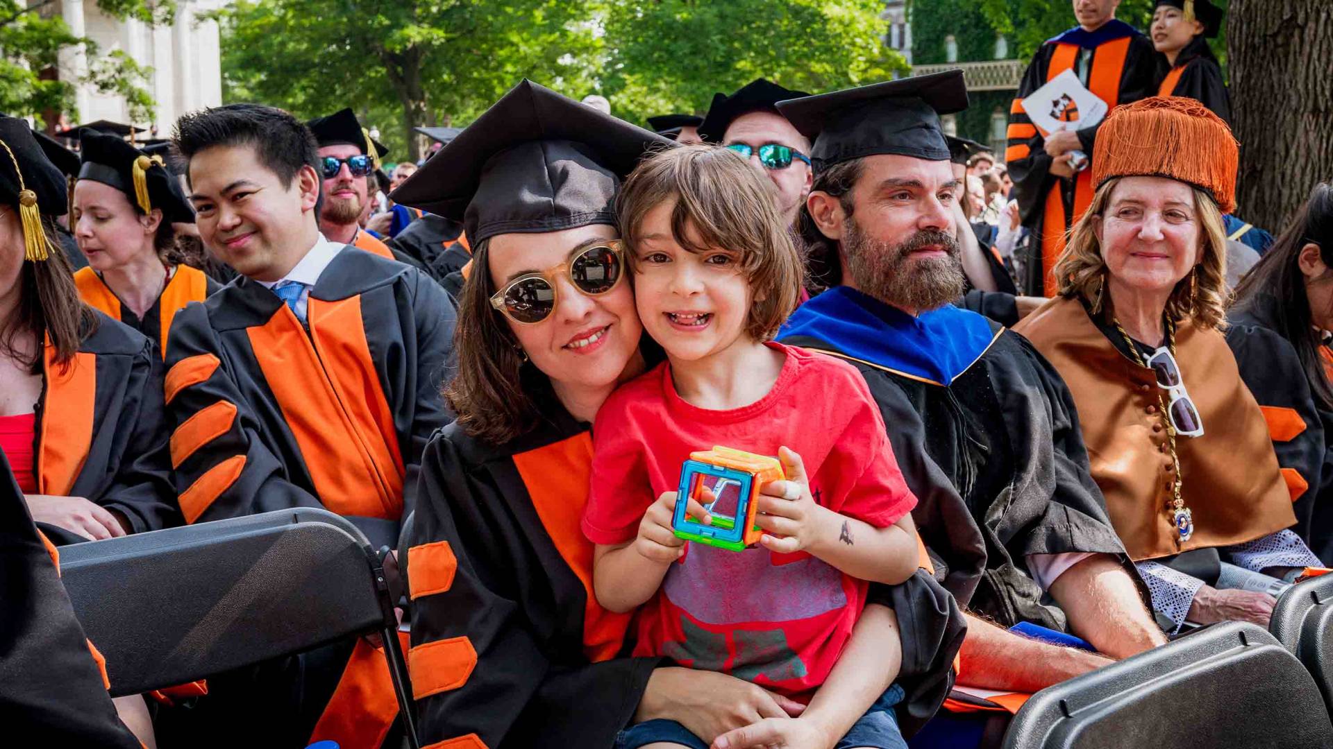 Graduating student smiling with her child.