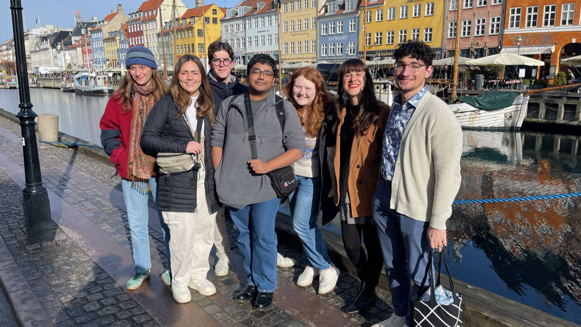 Group of students in front of a row of colorful buildings