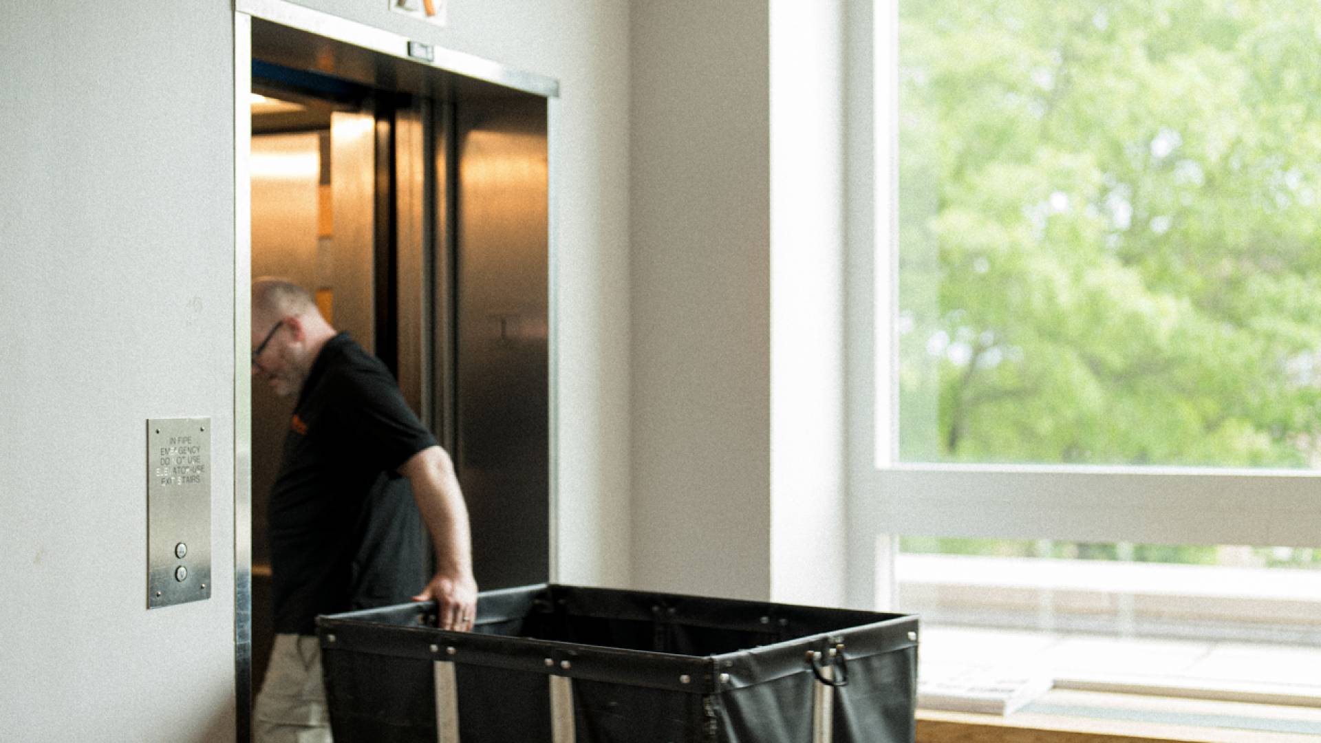 A person with a trolley entering an elevator