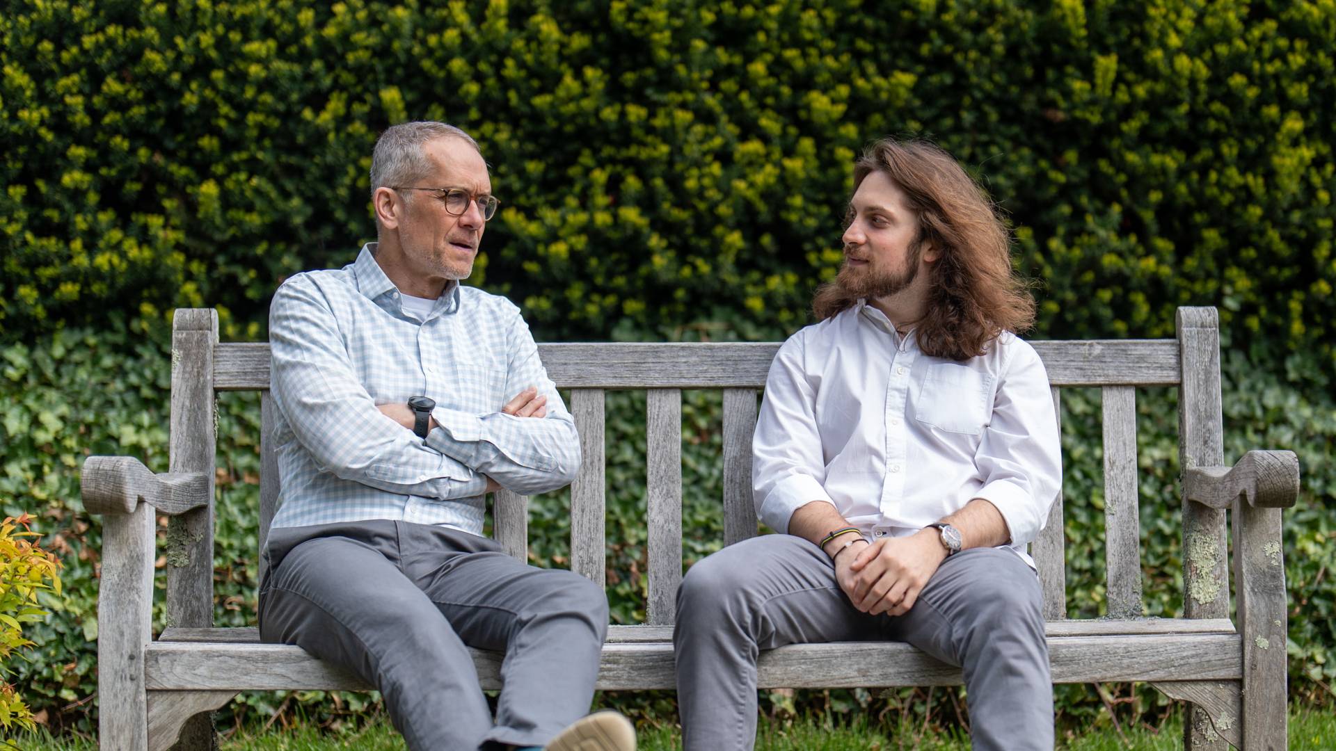 Ethan with his adviser sitting on a bench, talking.