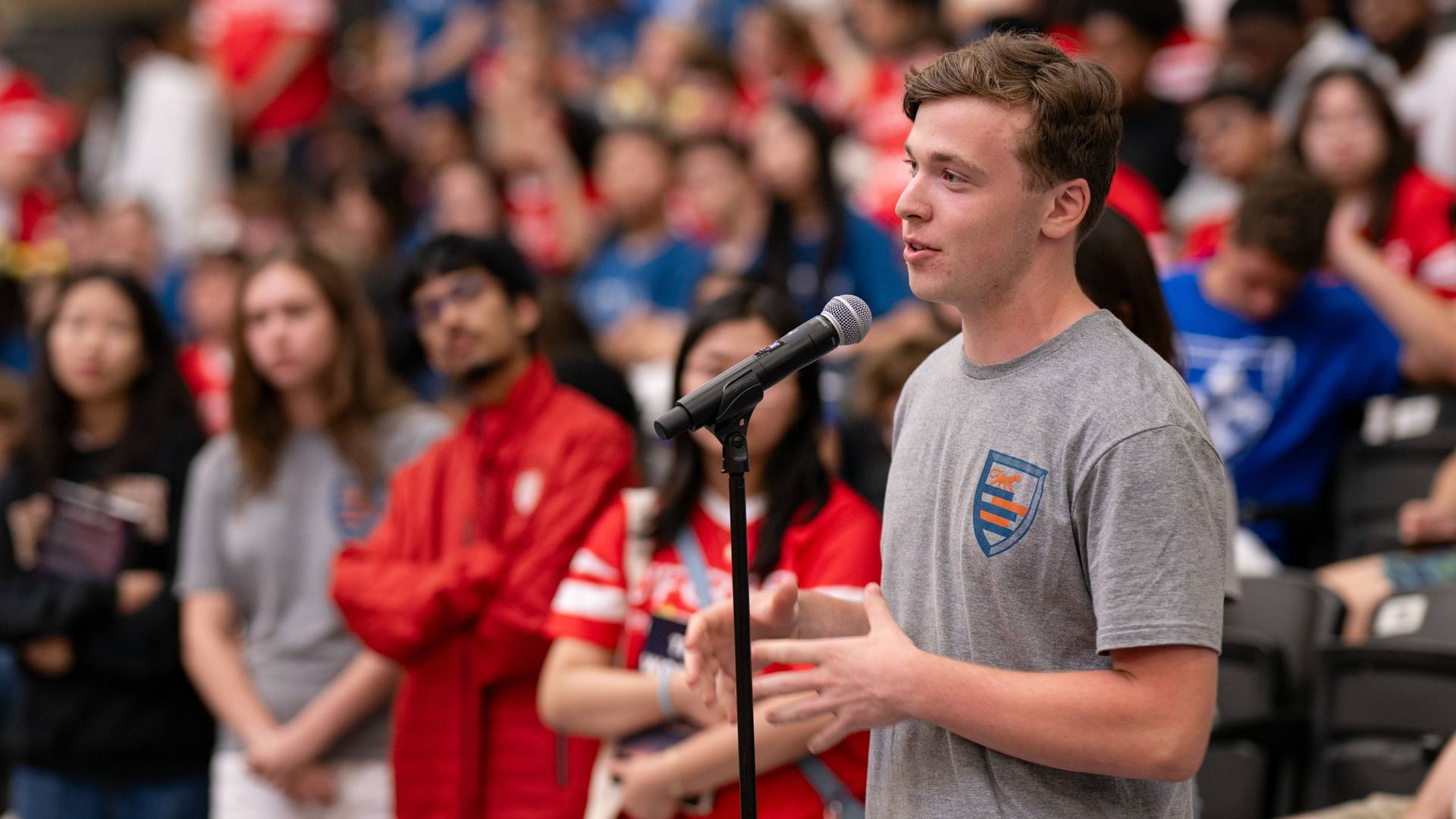 Student in front of a microphone asking questions