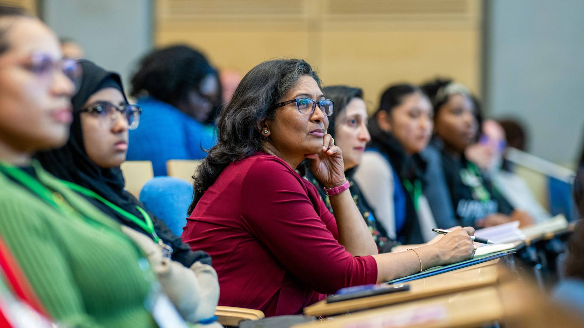Lady sitting in a crowd listening intently.