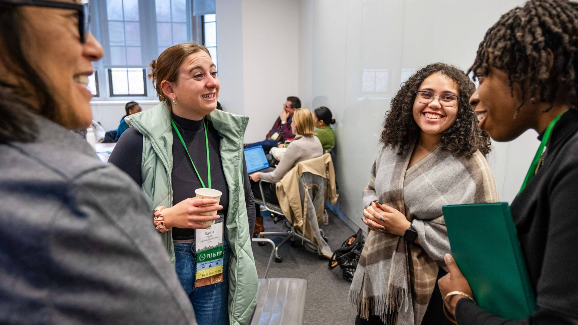 A group of women smiling, talking to each other.
