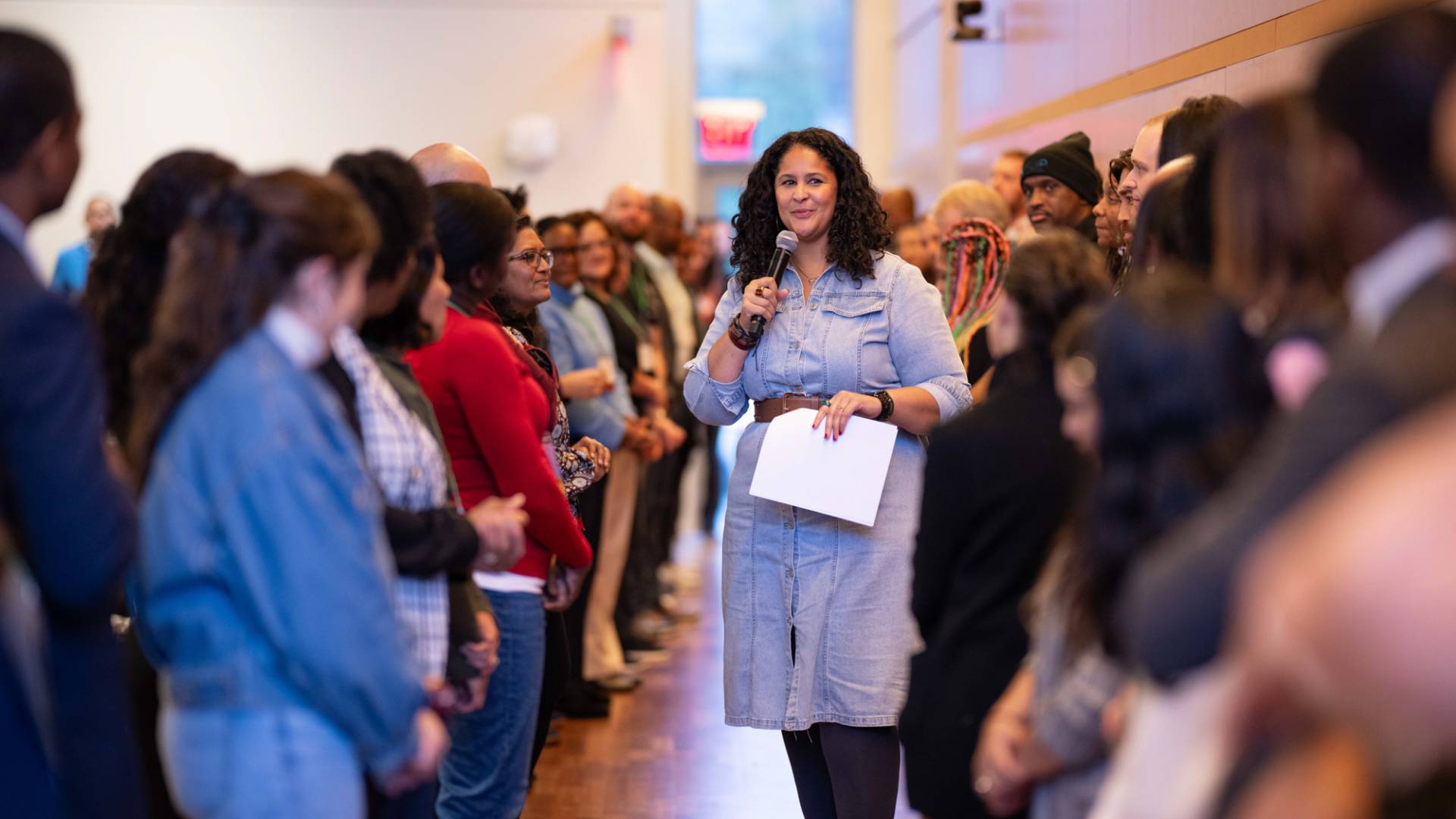 A lady standing in the middle of a big group of people.
