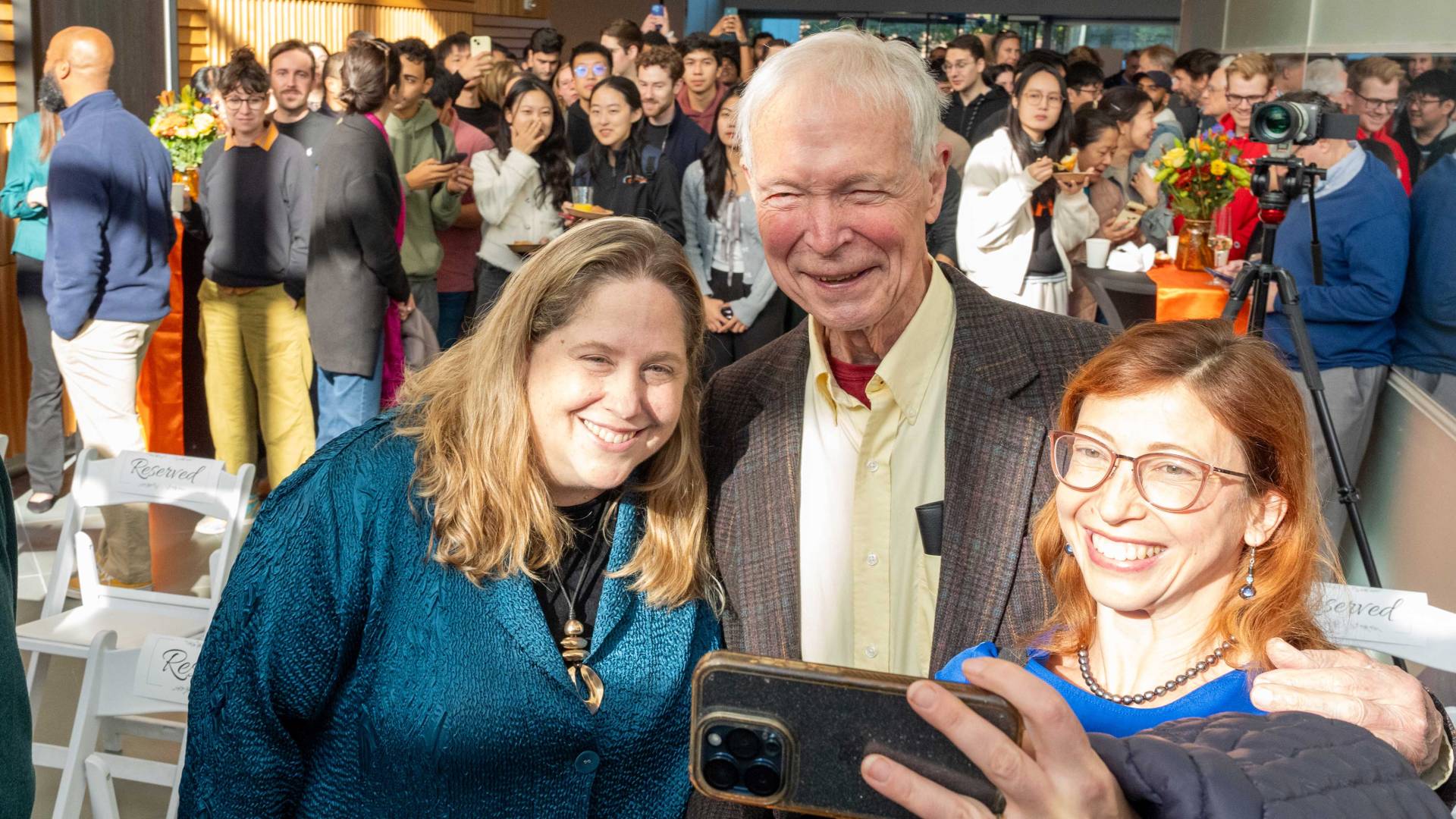 A pair of former students take a selfie with John Hopfield