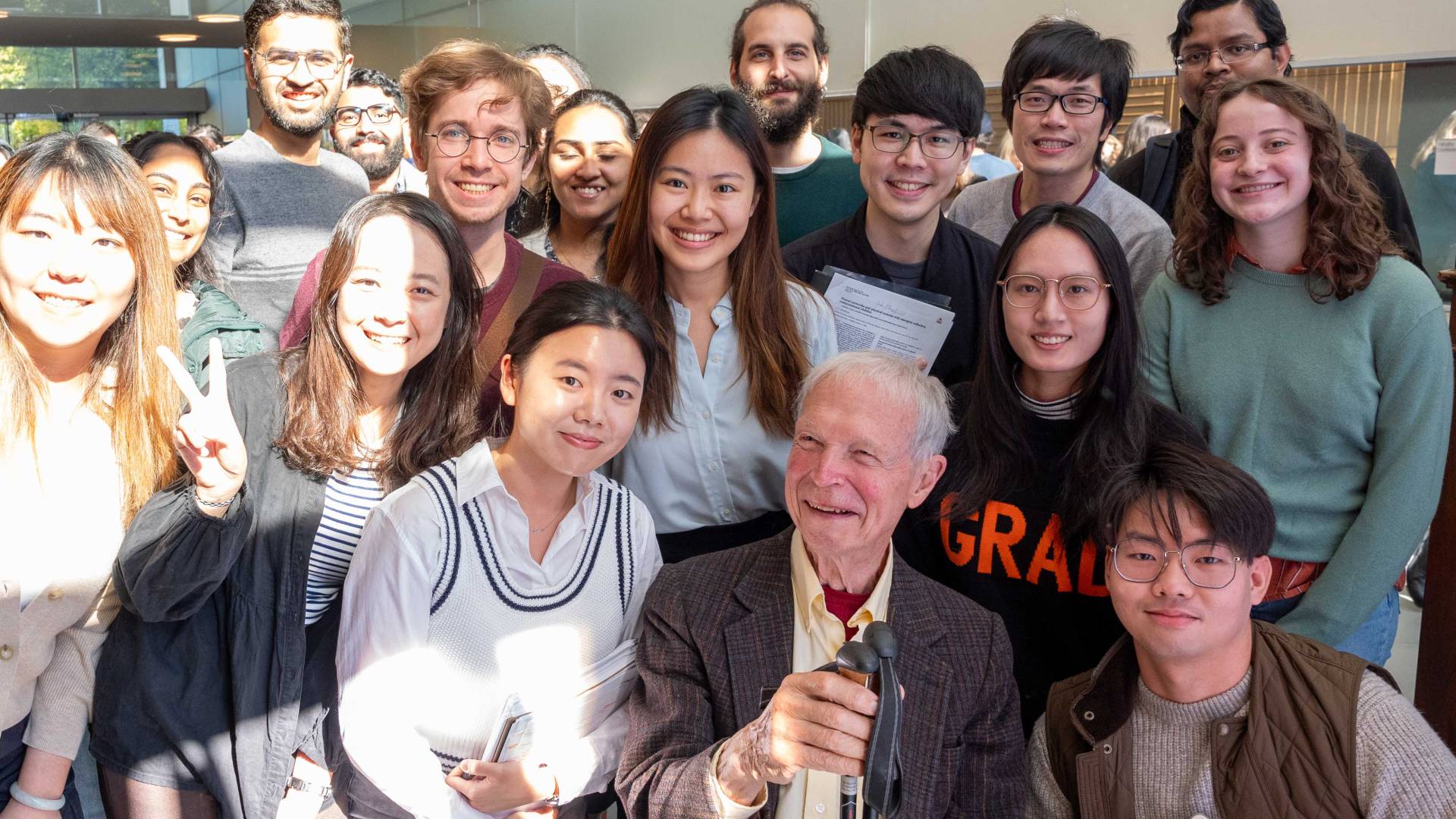 A crowd of students gather to pose for a photo with Hopfield