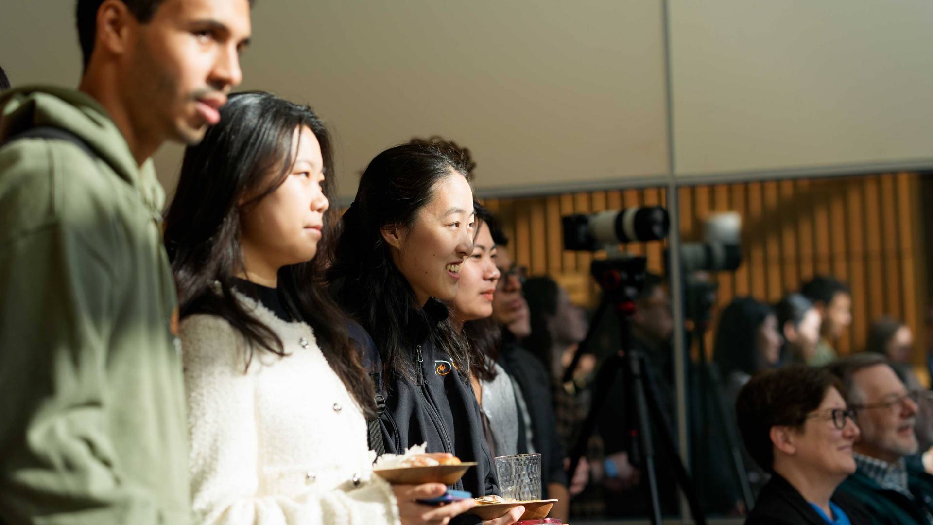 An enthusiastic crowd watches the speakers at the reception