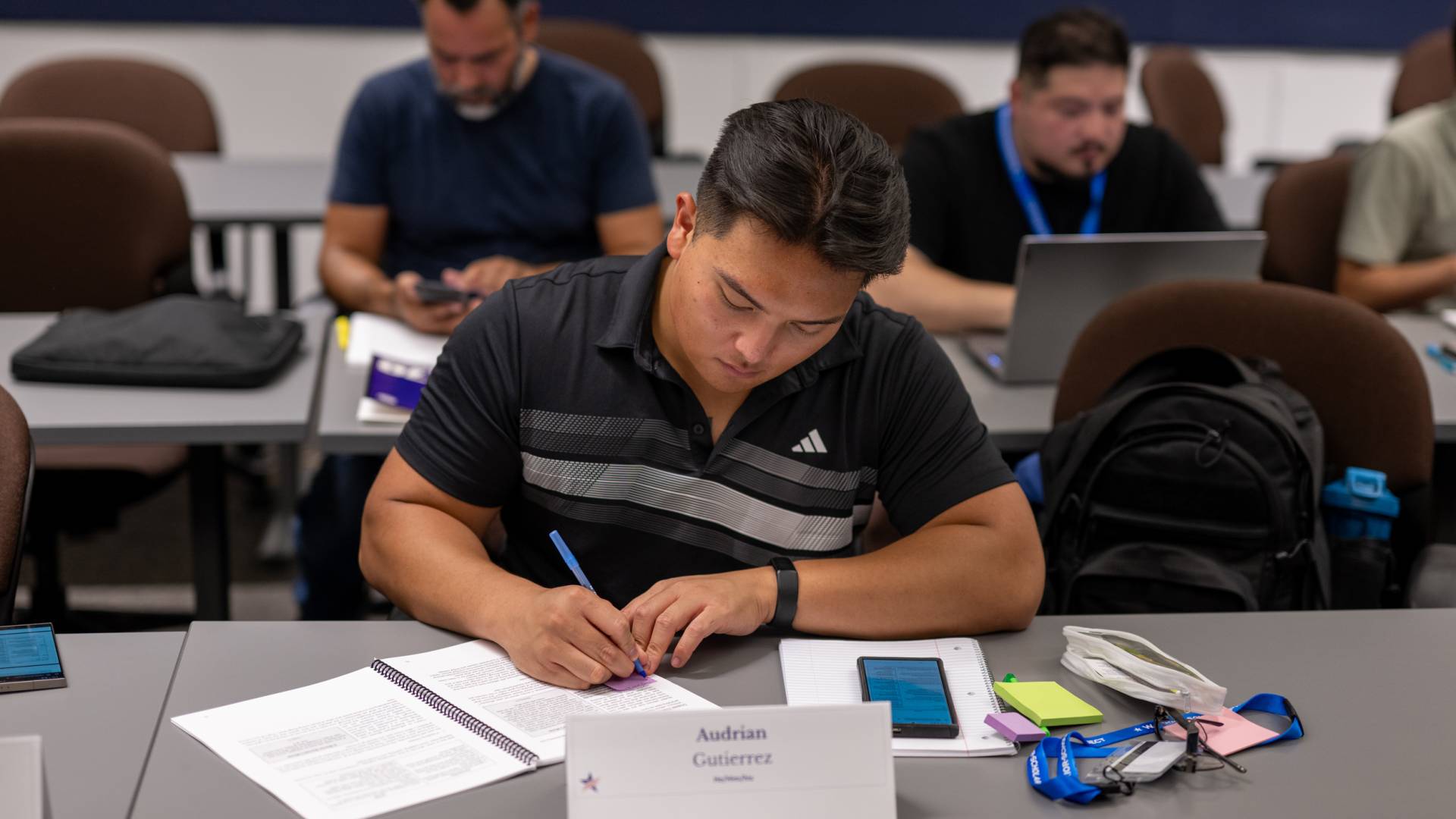 Audrian Gutierrez works on an assignment in class by marking up a set of papers.