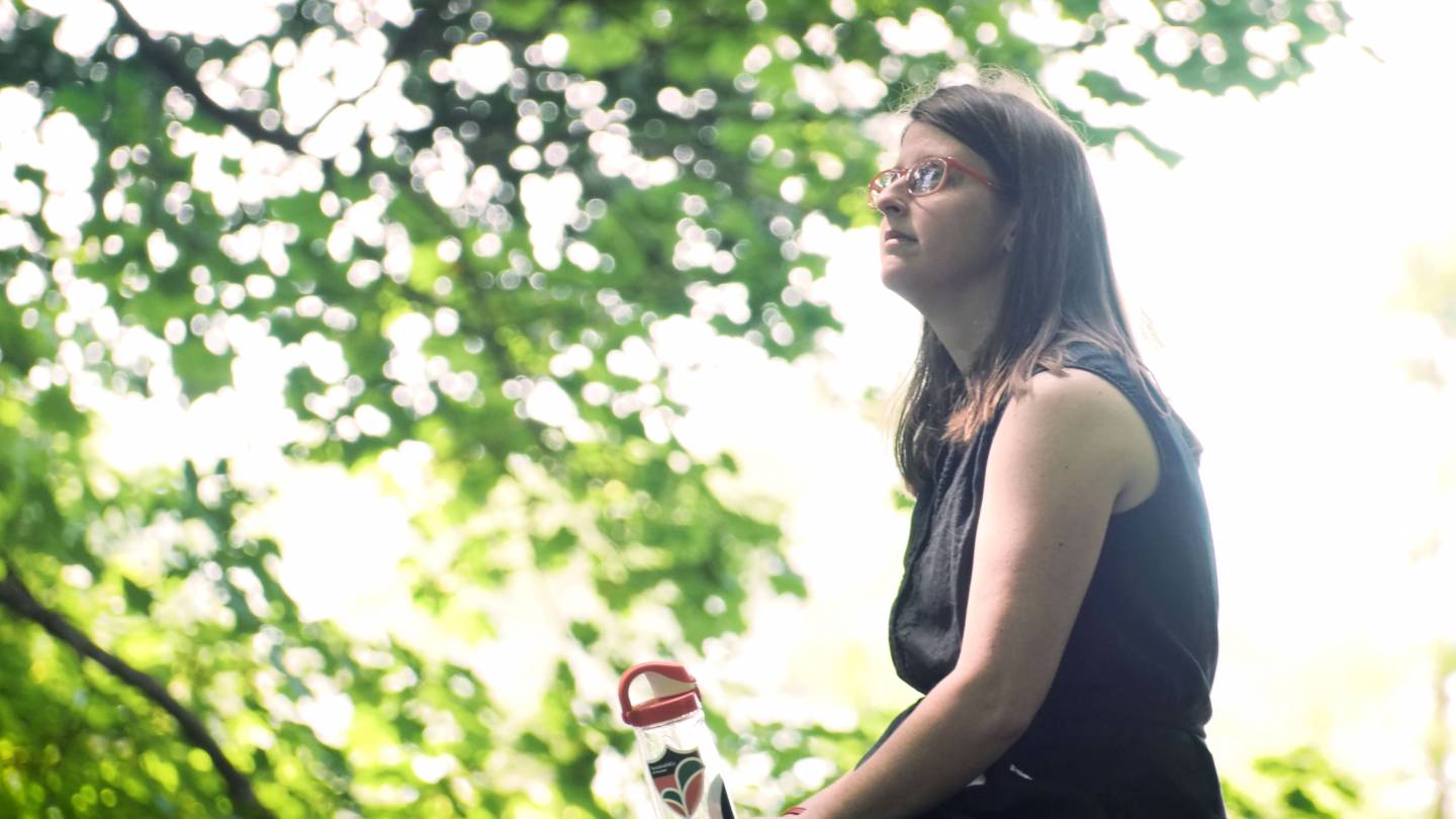 Gwen McNamara sitting on tree stump