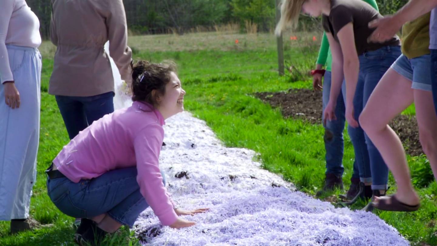 Student crouching in field