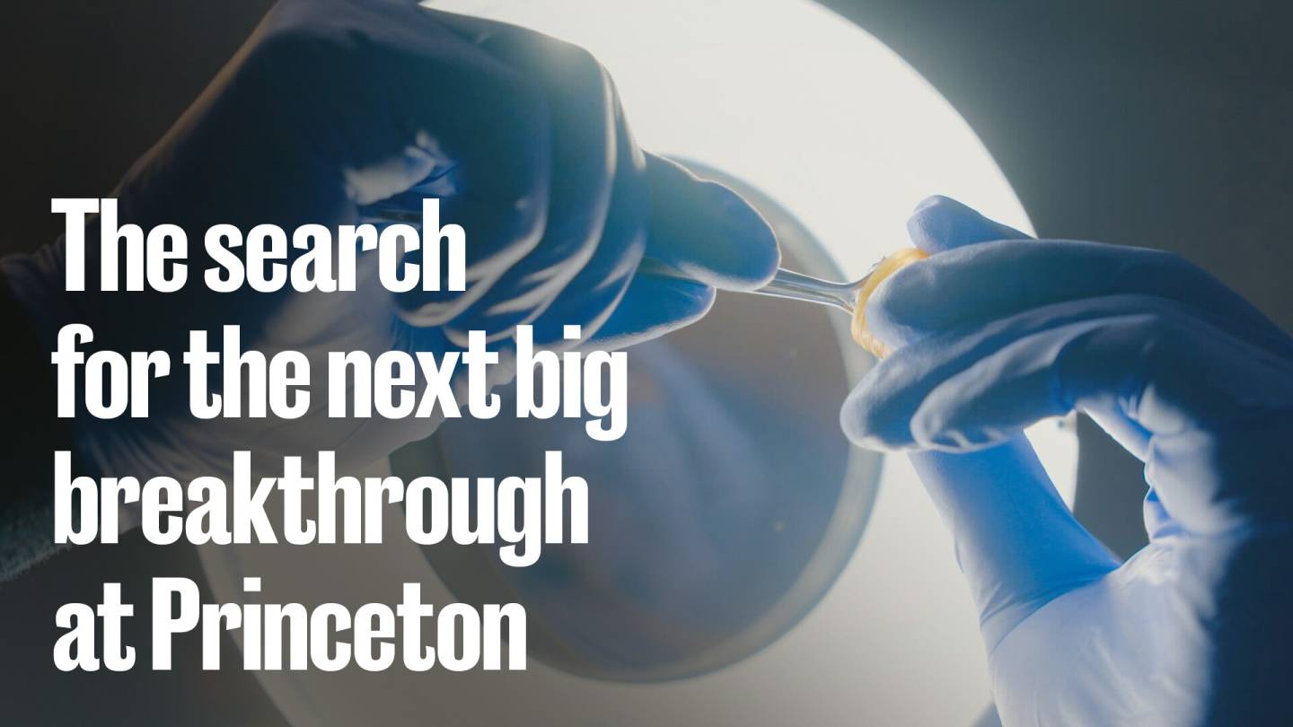 Gloved hands with a test tube.