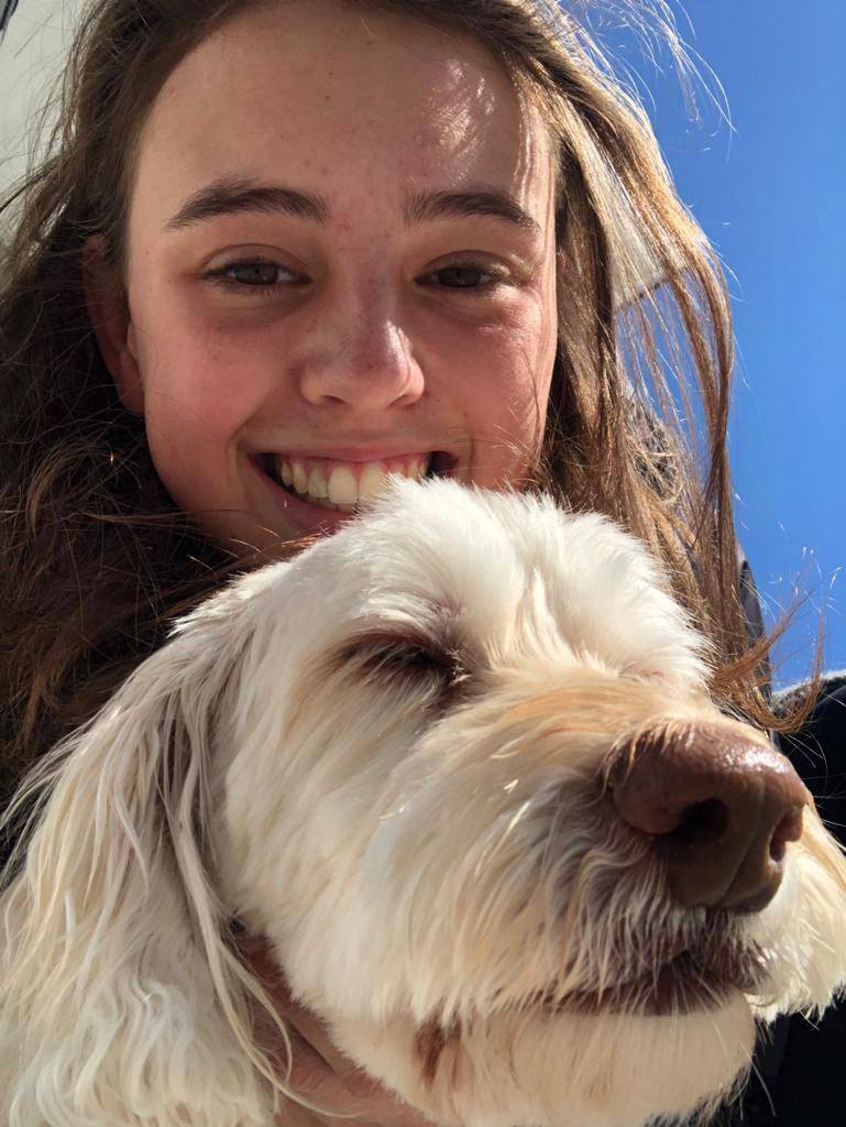 A student hugs her dog