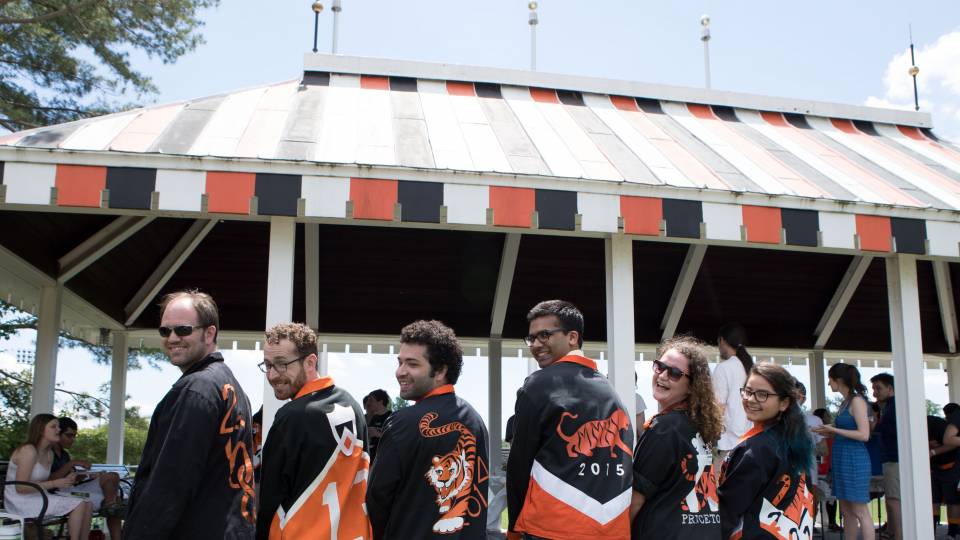 Six alumni pose with their class jackets