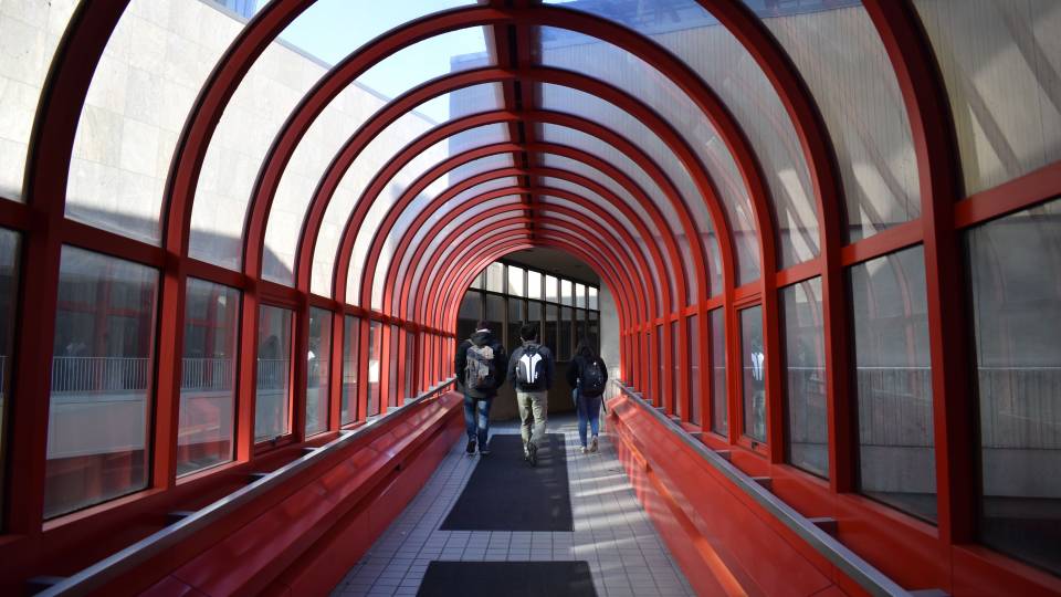 Students walking through red steel arch in Detroit