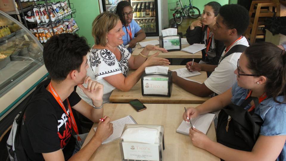 Students in Summer Journalism Program interview store owner