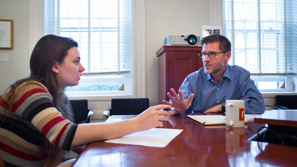 Joe Stephens talks with a student at a table