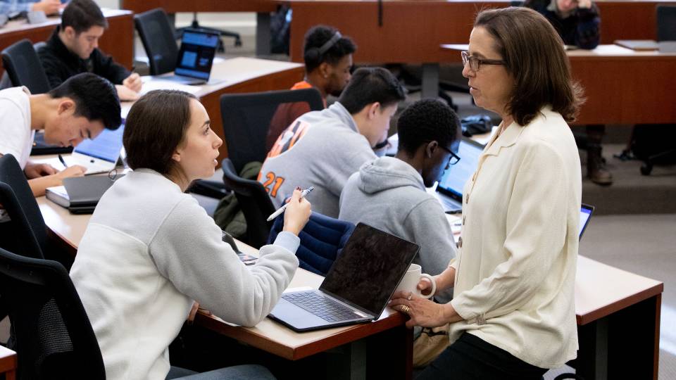 Student speaking with professor during class