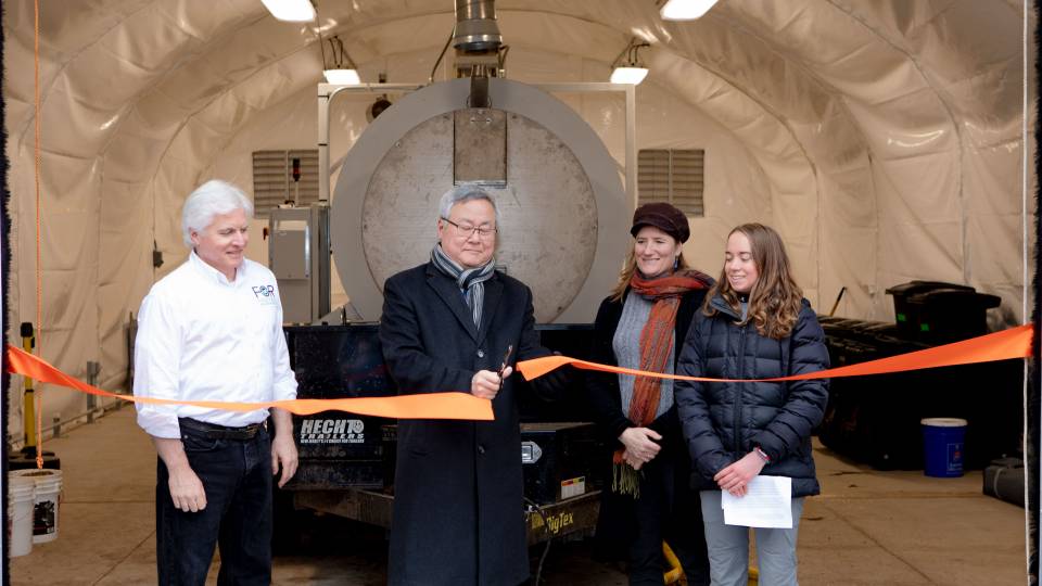 KyuJung Whang cutting ribbon in front of biodigester