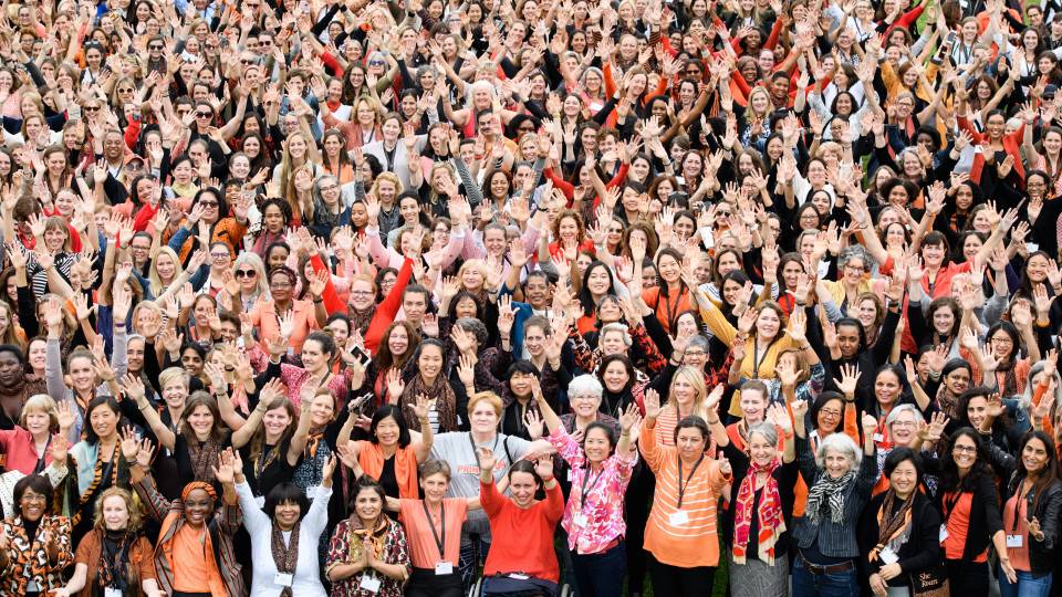 Crowd of women waving up to photographer taking their picture