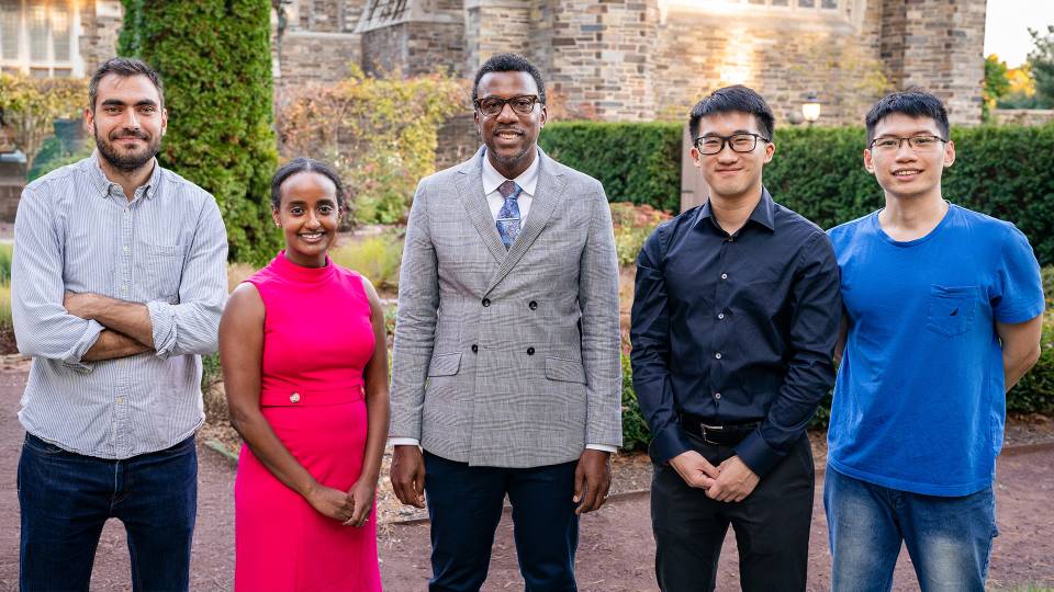 The four Jacobus Fellows of 2025 standing together in front of a garden
