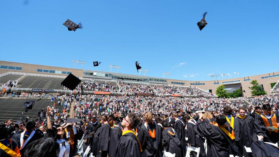 At Princeton Stadium, graduates toss their caps in the air.