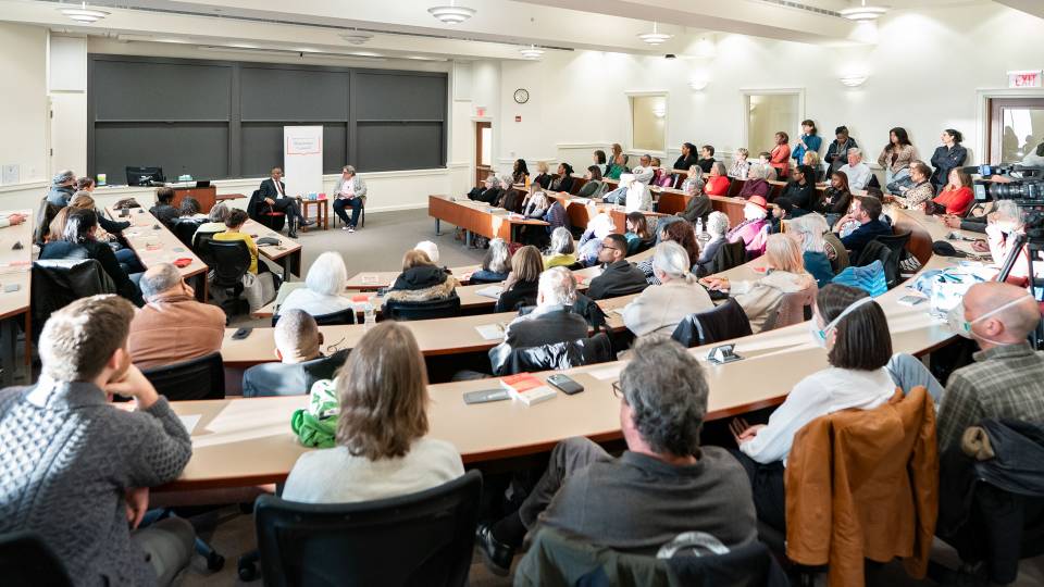 An audience listens to Princeton professors