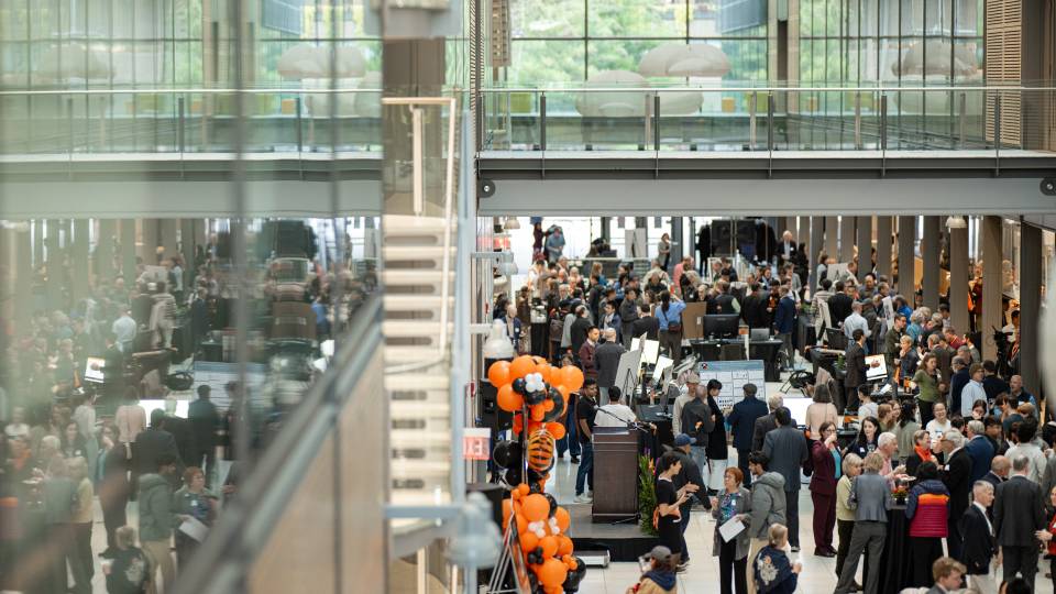 Event attendees gather in the glass-walled Frick atrium.