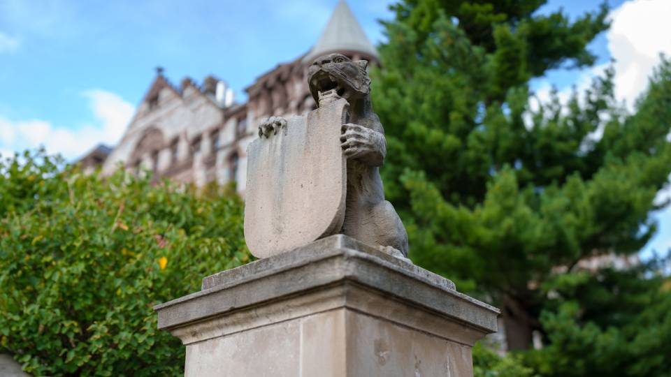 Stone carving of a small tiger atop a pedestal on Princeton's campus