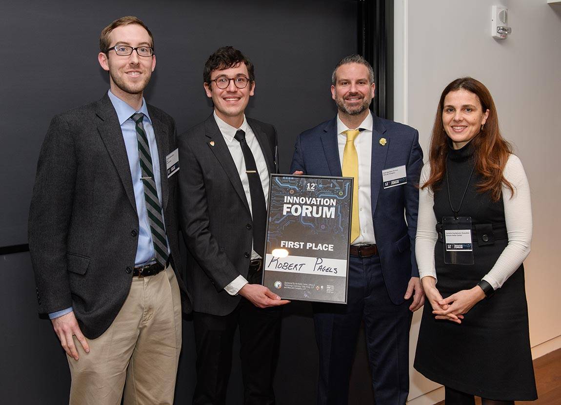 Graduate student Robert Pagels of chemical and biological engineering delivers the event's winning pitch for a technology to package multiple doses of medicine into microscopically small particles for controlled release in a patient. He collaborated with fellow graduate student Chester Markwalter (left). Awarding the prizes were Mark Barbieri, a partner at the accounting firm Wiss and Co., and Cornelia Huellstrunk, executive director of Princeton's Keller Center.