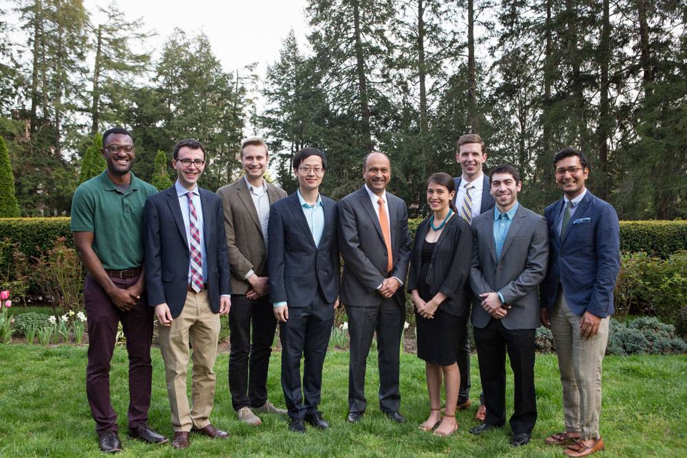 Graduate school teaching honorees pose with Dean of the Graduate School Sanjeev Kulkarni, standing on a lawn.